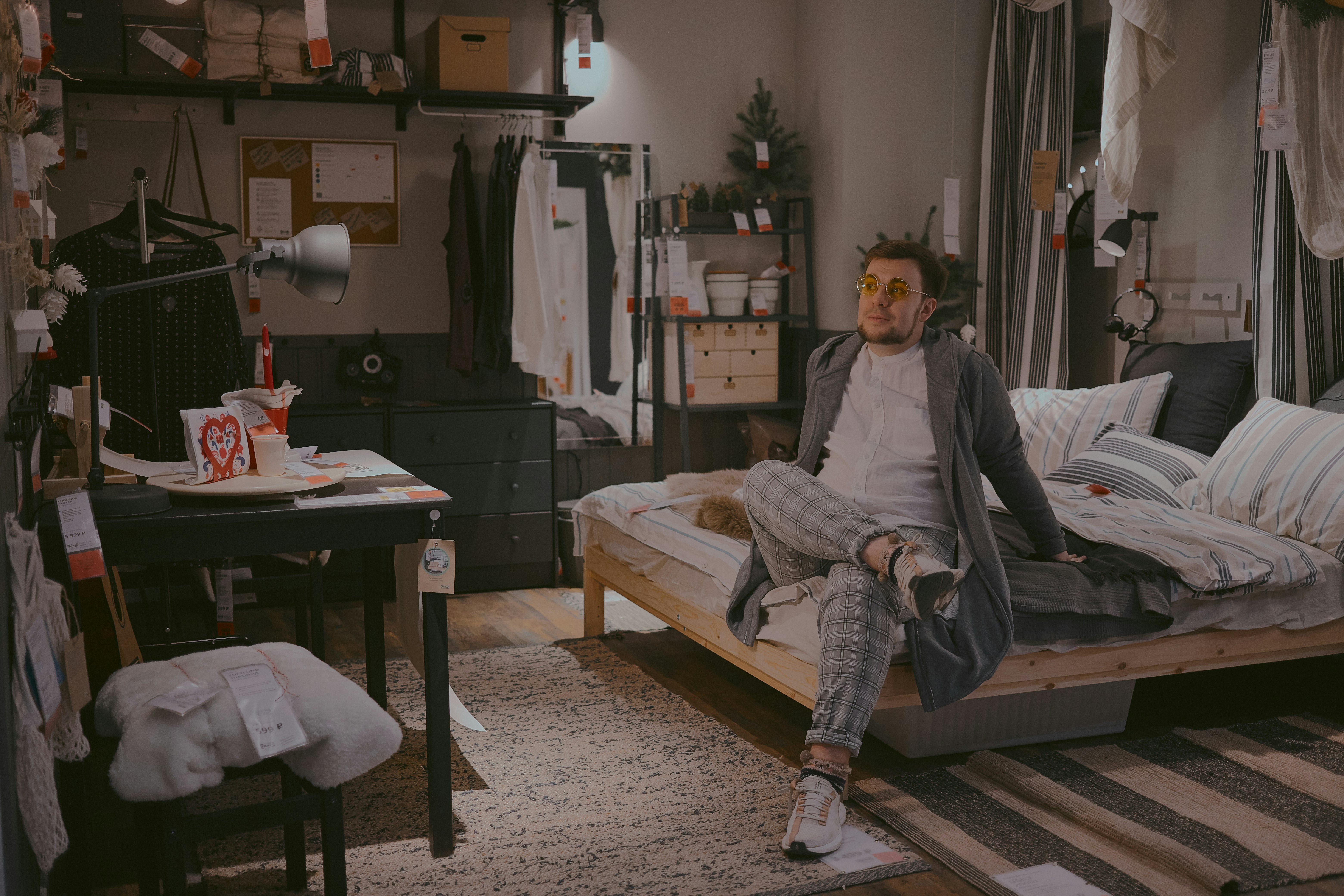 woman in gray jacket sitting on brown wooden bed